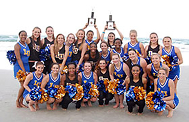 cheerleaders and dance team with trophies