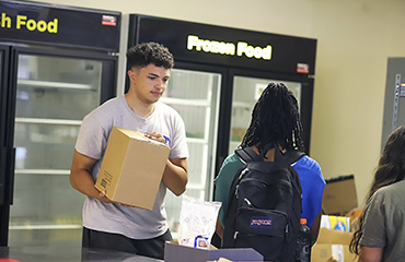 Devon Watson stocks shelves at the Bear Necessities Food Pantry